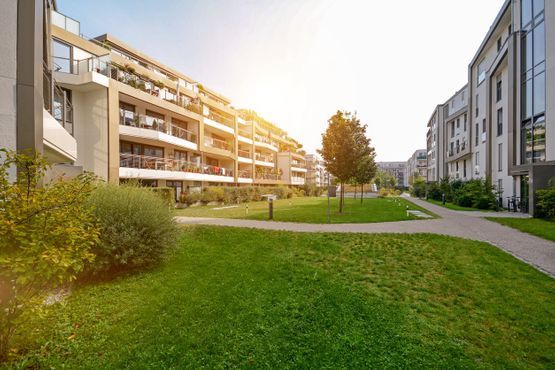 Una hilera de edificios de apartamentos con un exuberante césped verde frente a ellos.