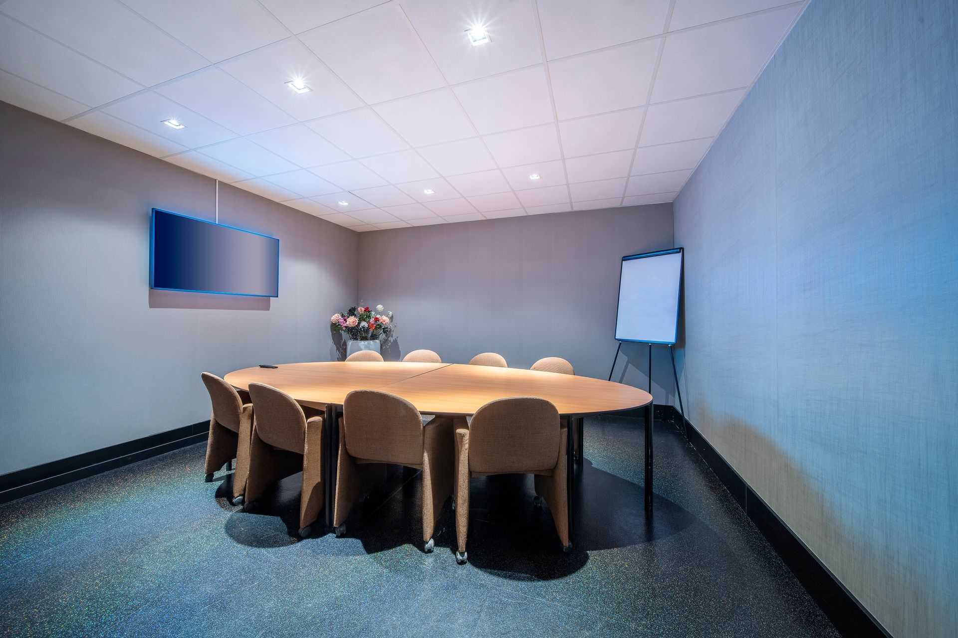 Een conferentieruimte met een lange tafel en stoelen.