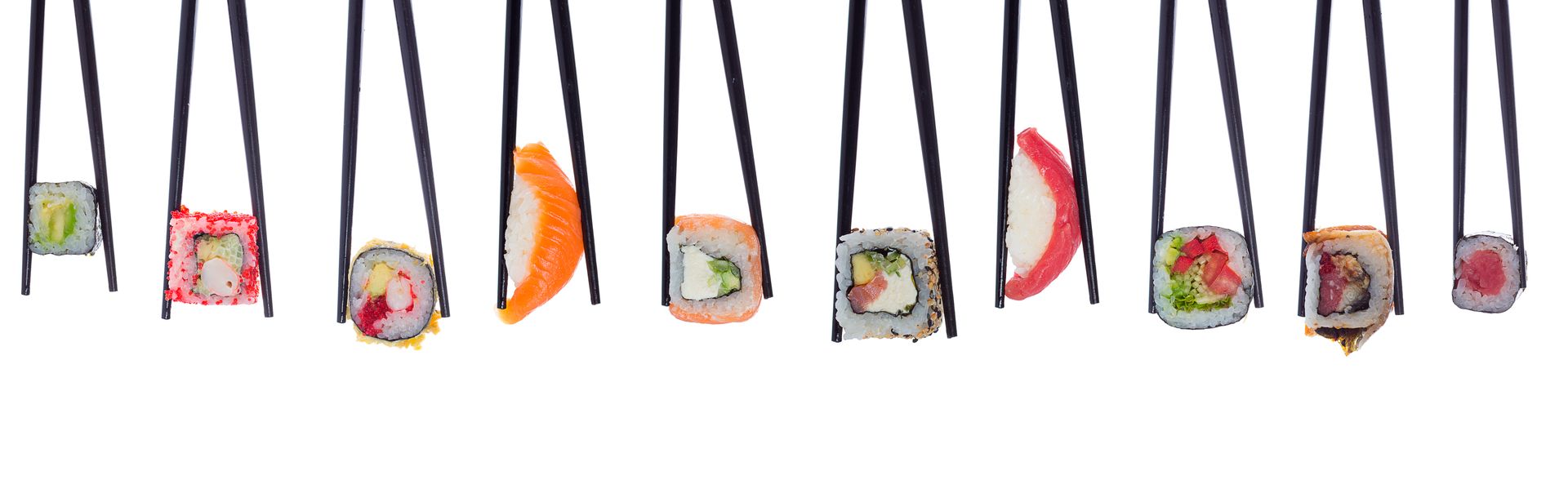 Plusieurs styles de sushis et de makis tenus par des baguettes