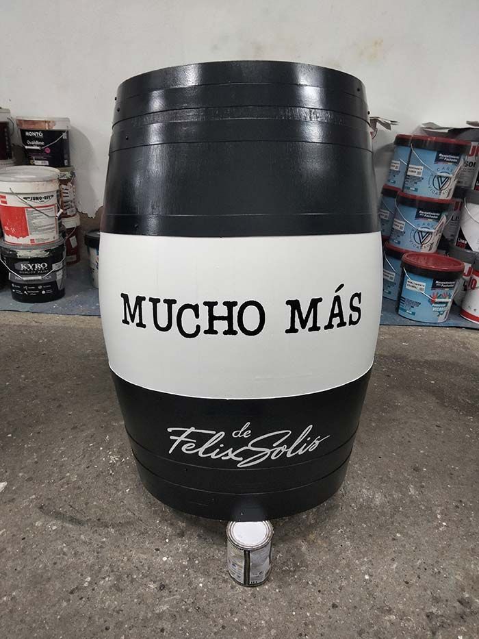 Barril negro con una banda blanca que dice 