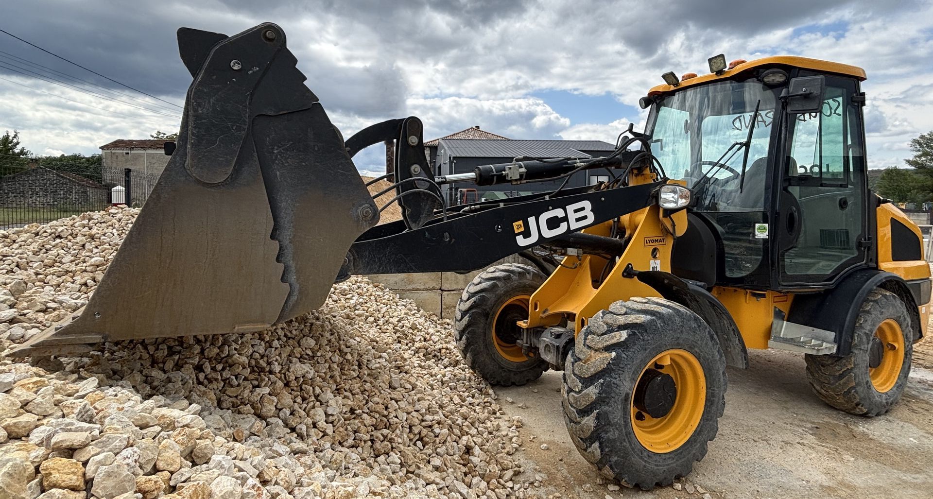 Chargeuse UCB devant un tas de pierre