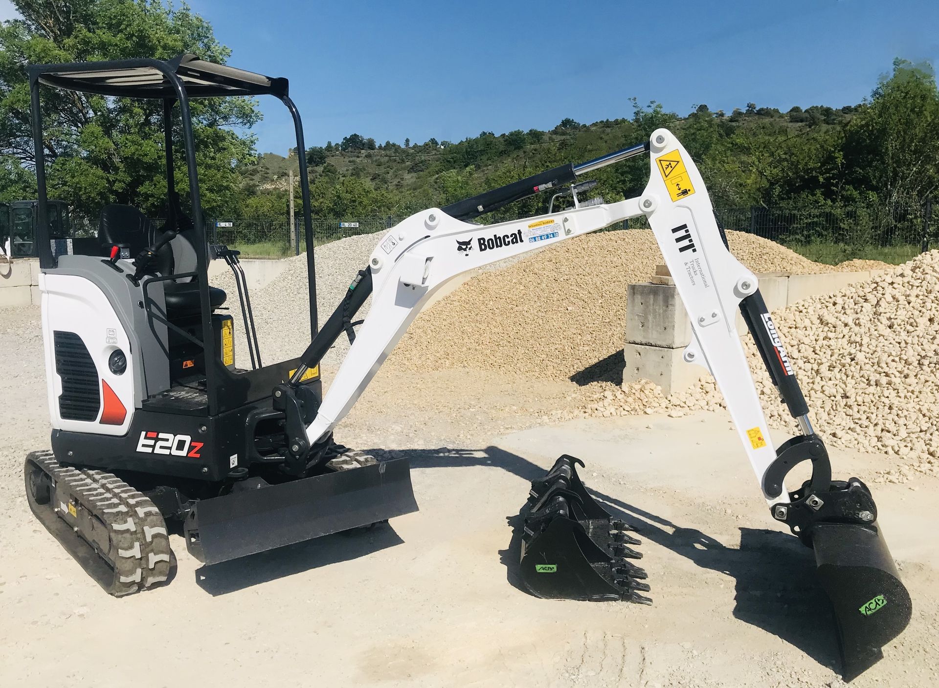 Excavatrice blanche et noire sur un terrain