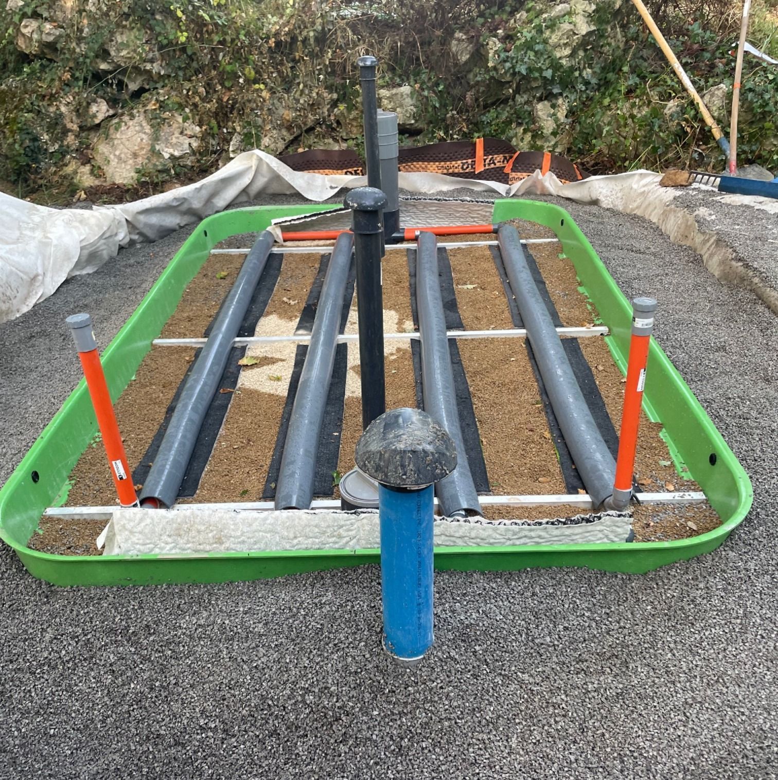 Zone d'épandage avec des tuyaux et un entourage vert