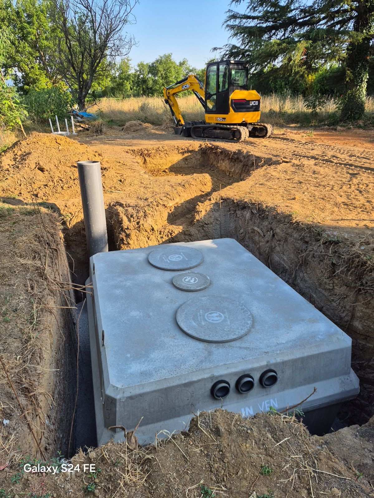 Terrain avec un chemin creusé par une mini-pelleteuse orange
