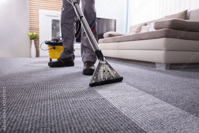Person saugt einen Teppich ab