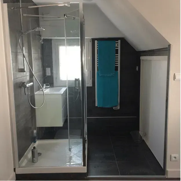 Salle de bain avec une douche à l'italienne et des serviettes bleues