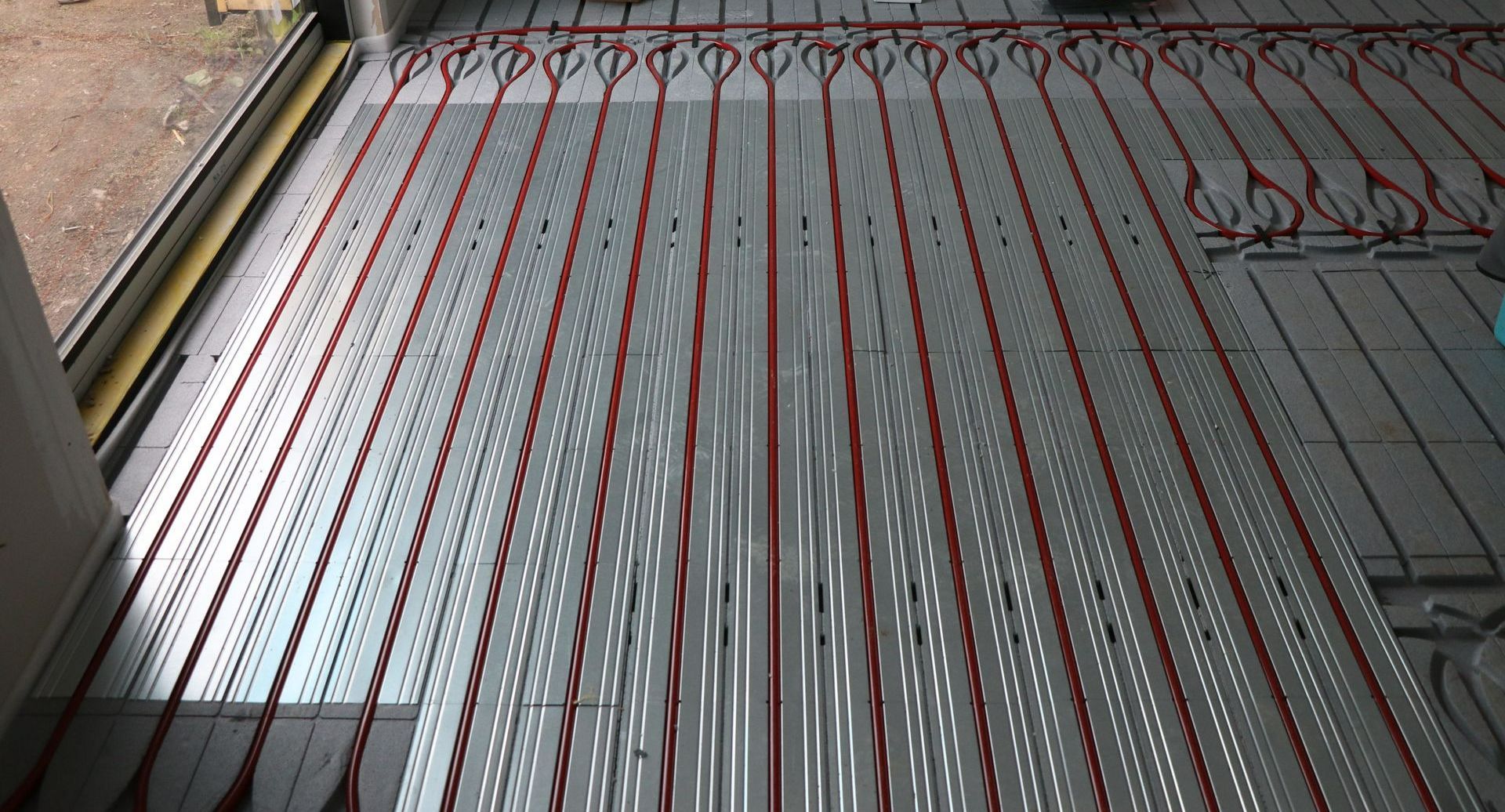 Plancher chauffant avec un morceau de conduit de chauffage apparent dans un salon