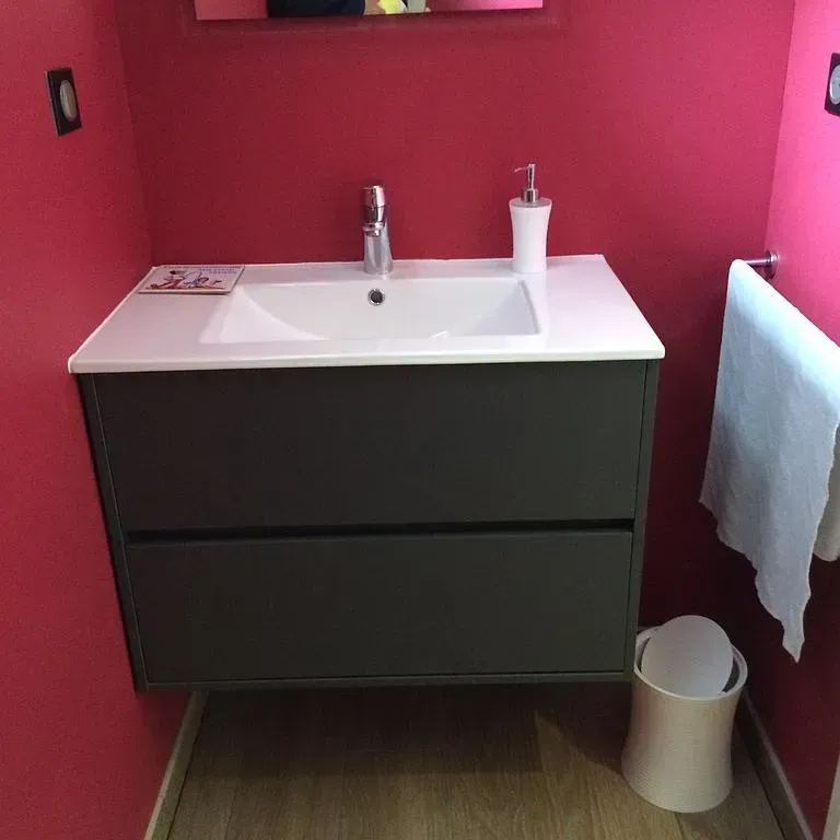 Evier de salle de bain sur un meuble avec des murs roses