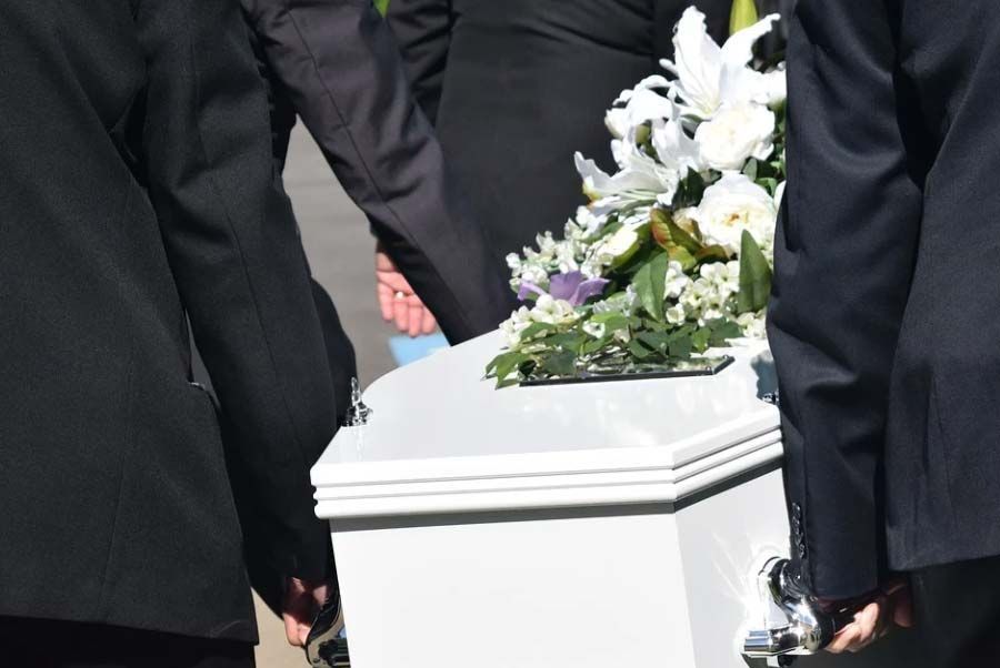 Hommes portant un cercueil blanc