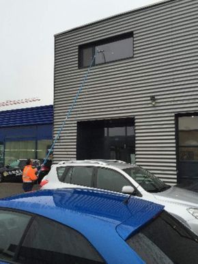 Mitarbeiter der Brühlmann Liegenschaftenbetreuungen GmbH reinigt Fenster von Gebäude