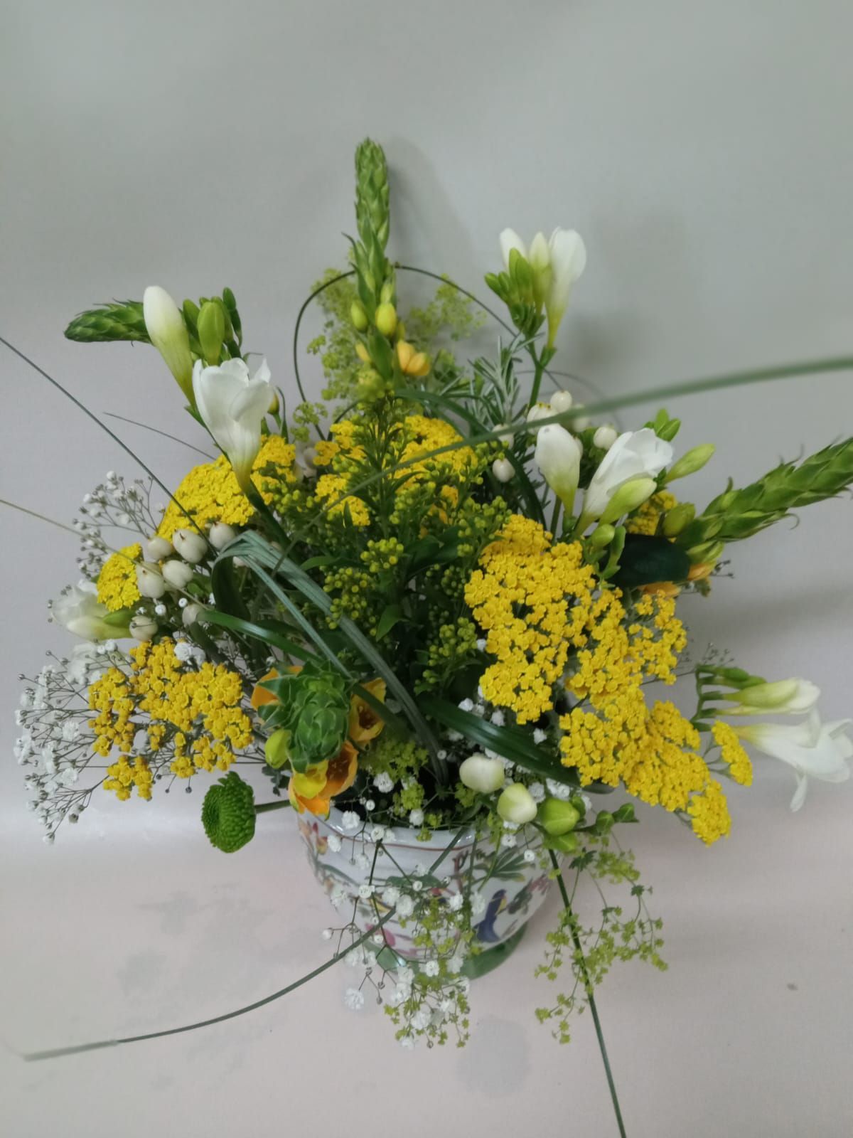 Un jarrón lleno de flores amarillas y blancas