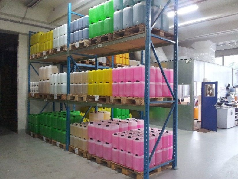 Lagerregale vollgestopft mit bunten Plastikkanistern und -behältern auf Paletten.