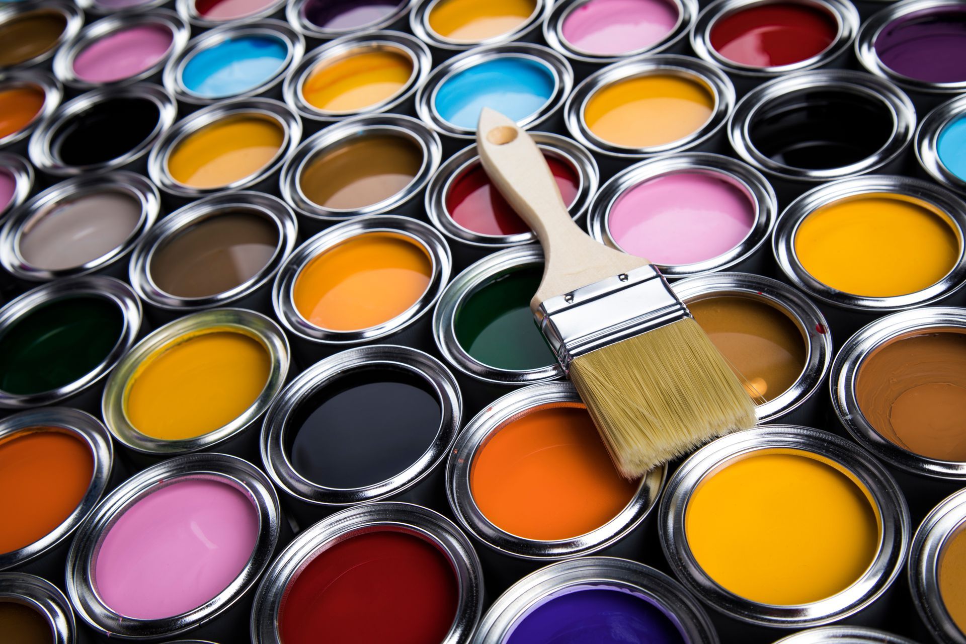 Des pots de peinture et un pinceau.