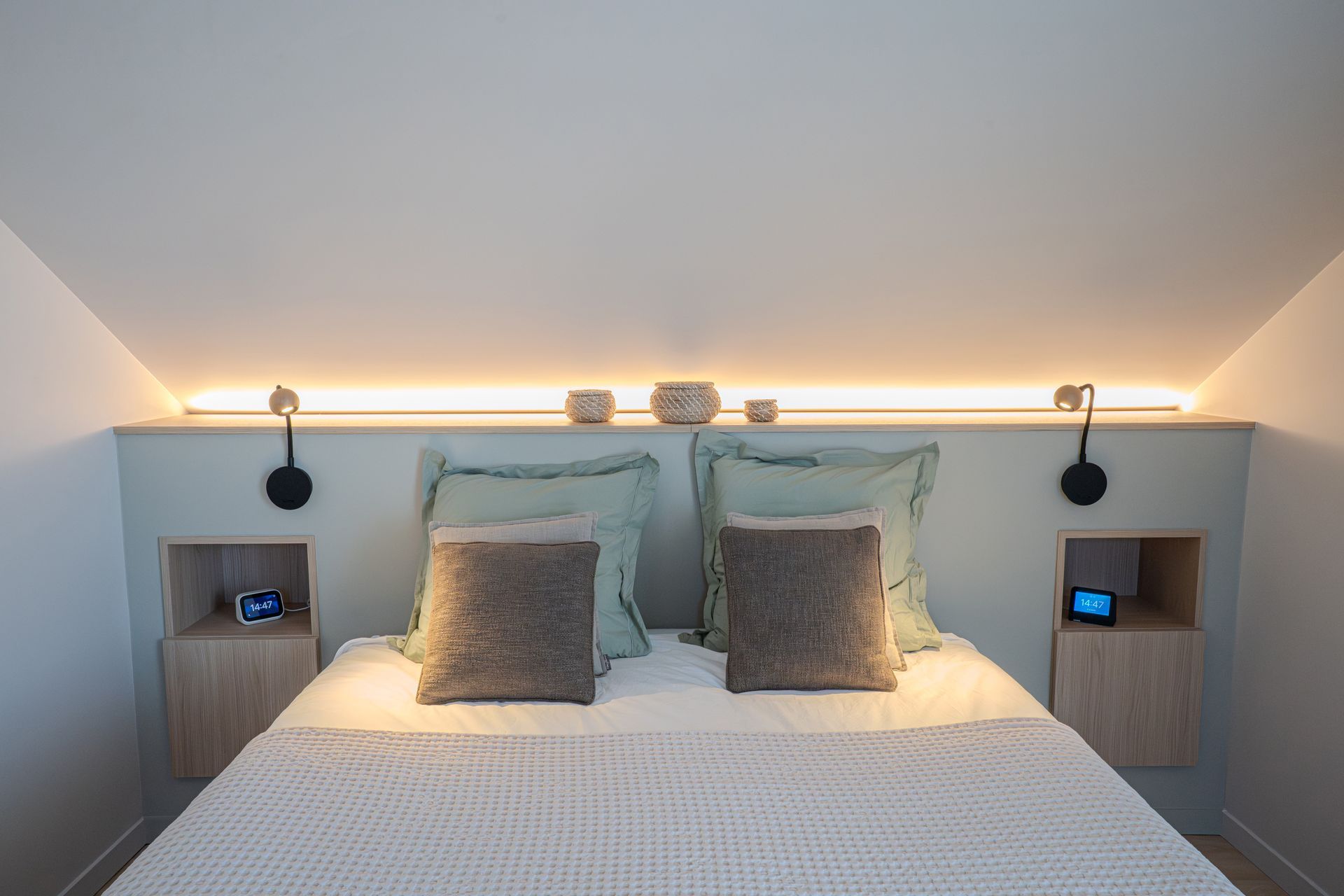 Un lit avec deux tables de nuit encastrées.