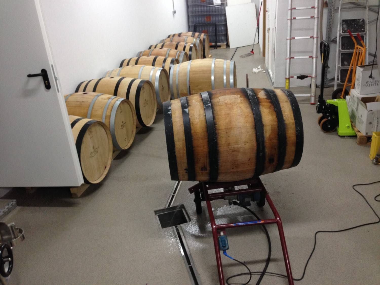 Una hilera de barricas de madera para vino en una bodega