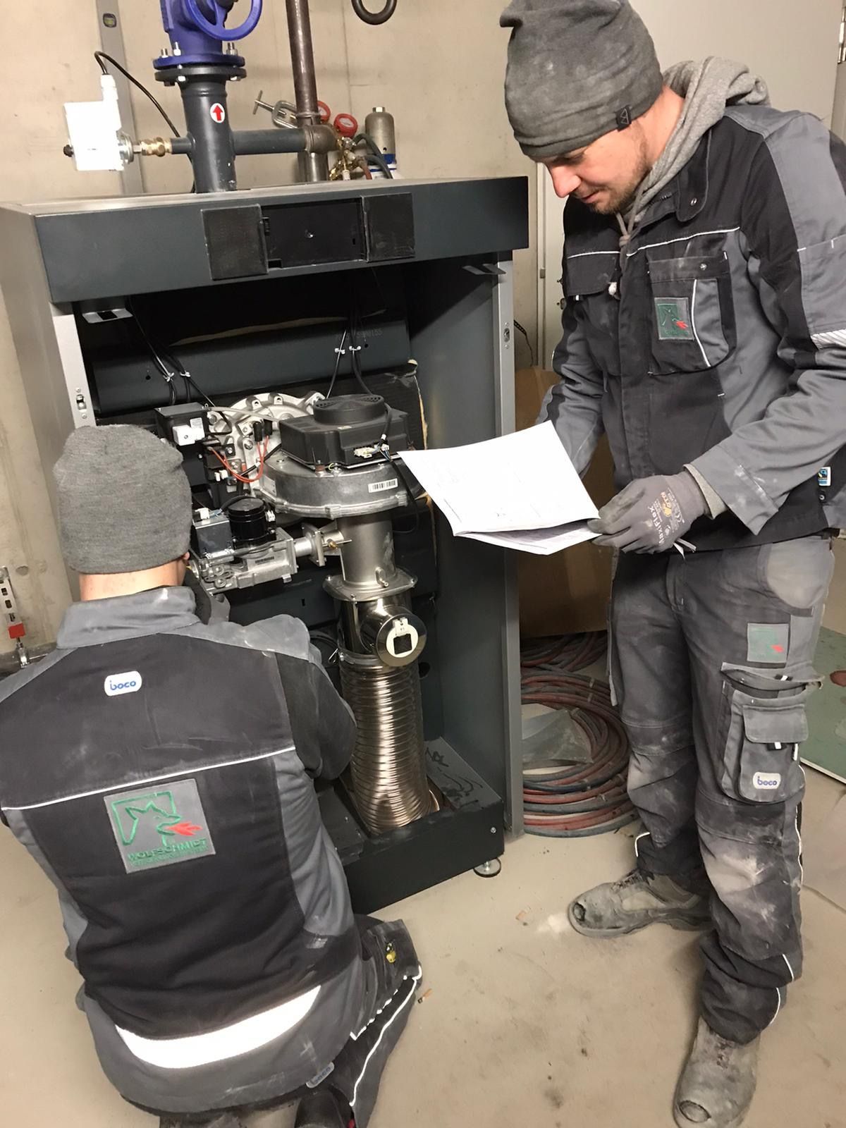 Zwei Männer arbeiten in einem Raum an einer Maschine.