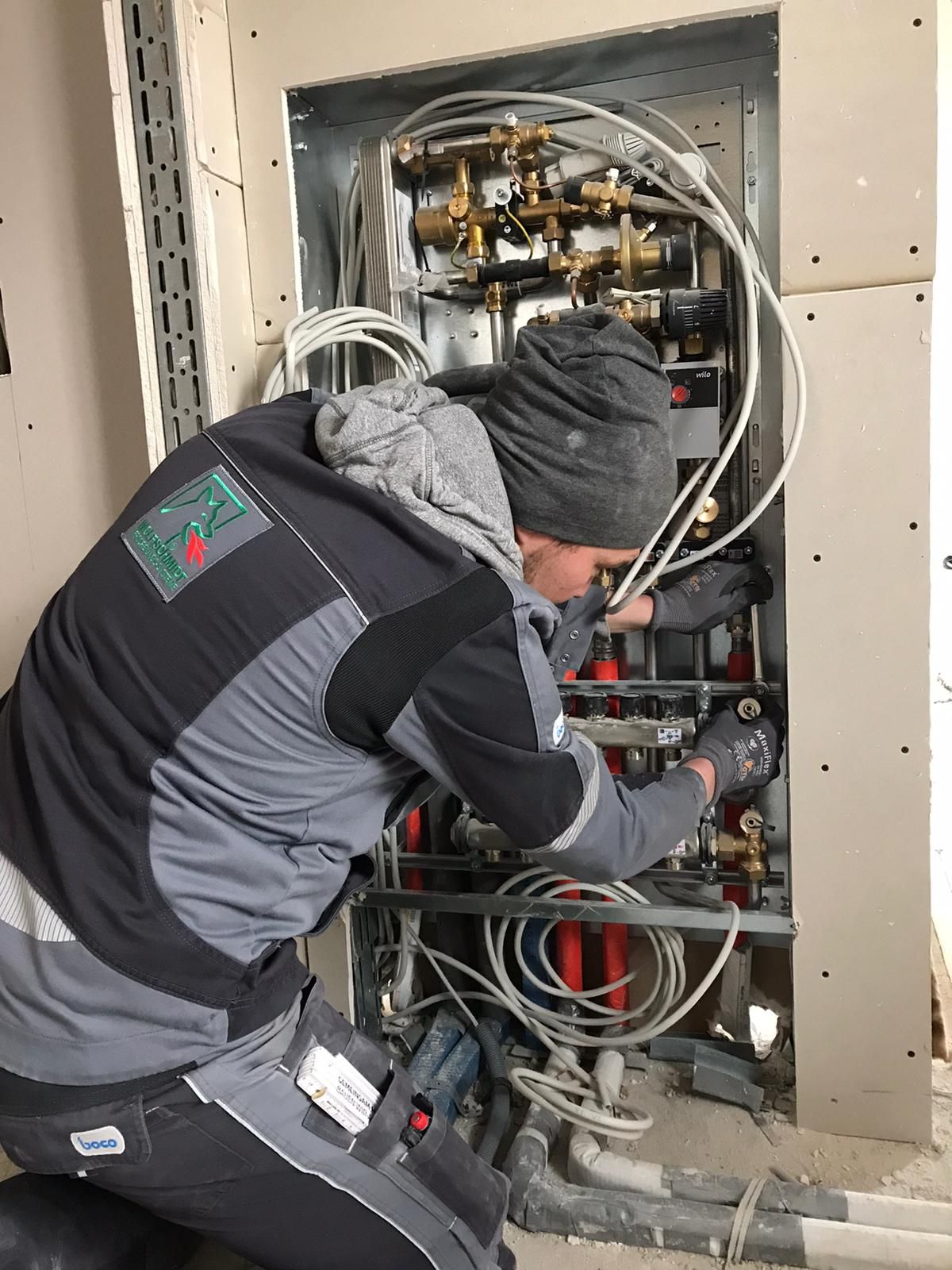 Ein Mann arbeitet in einem Raum an einer Maschine.