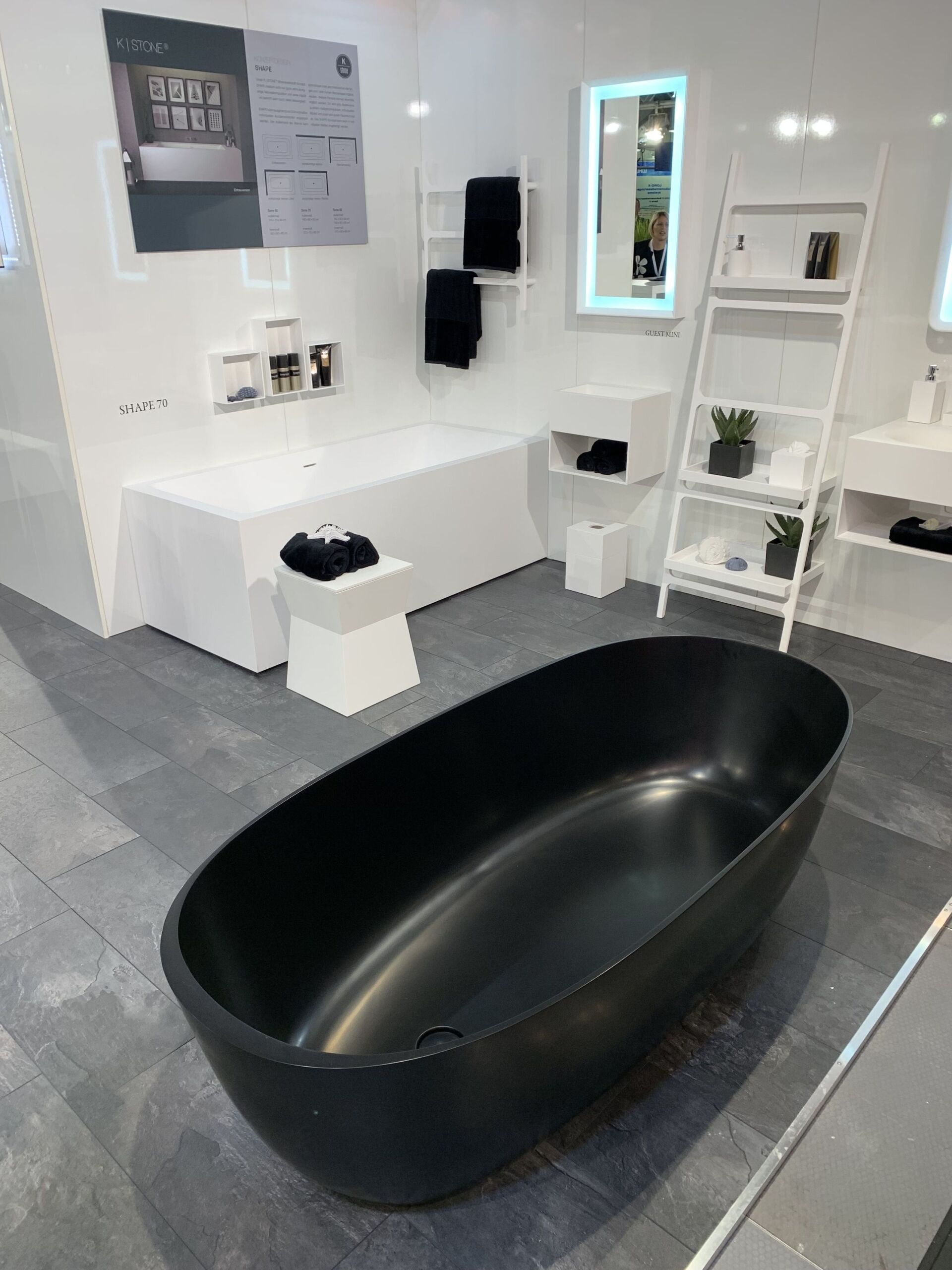 In einem Badezimmer steht eine schwarze Badewanne neben einem Waschbecken.