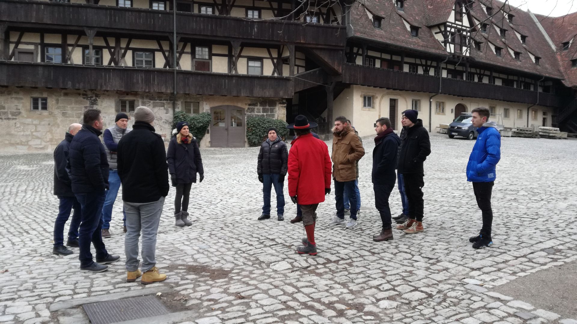 Eine Gruppe von Menschen steht im Kreis vor einem Gebäude