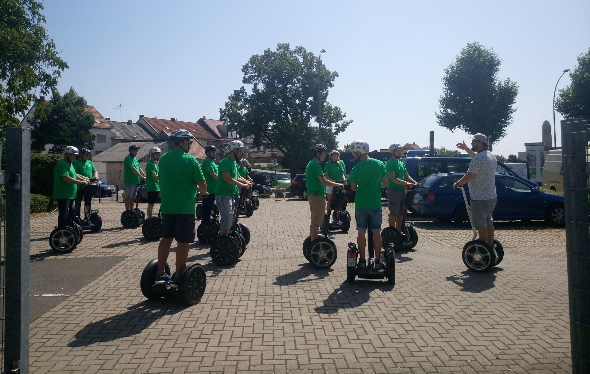 Eine Gruppe von Menschen in grünen Hemden fährt Segways