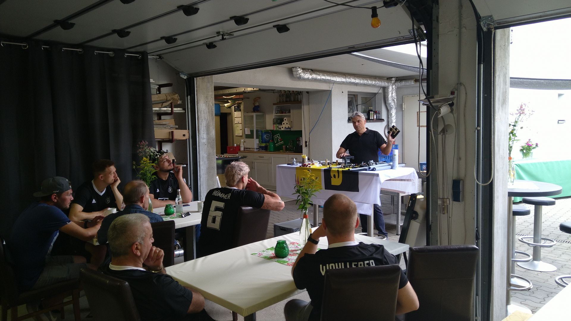 Eine Gruppe von Menschen sitzt in einem Raum an Tischen.