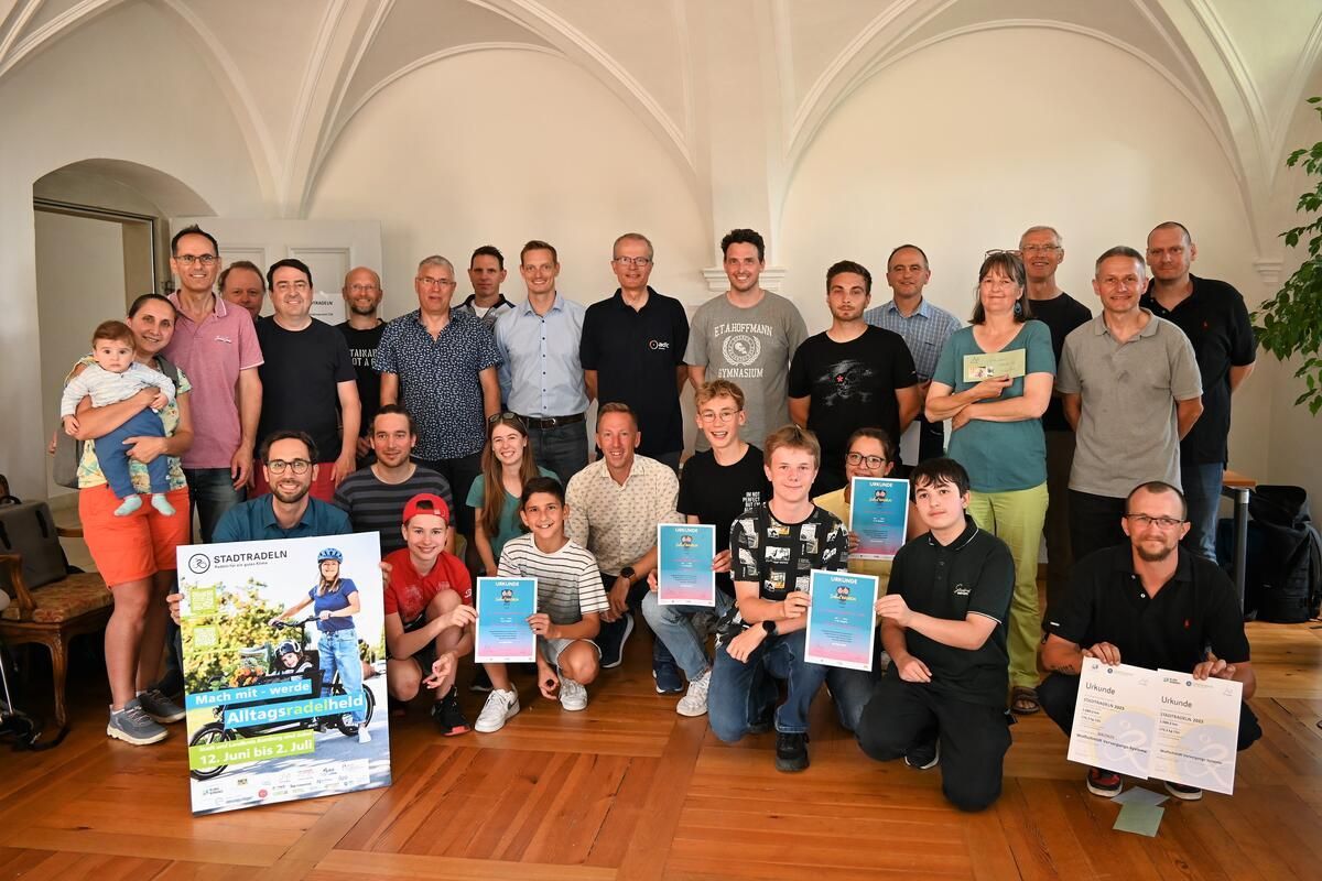 Eine Gruppe von Menschen posiert in einem Raum für ein Foto.