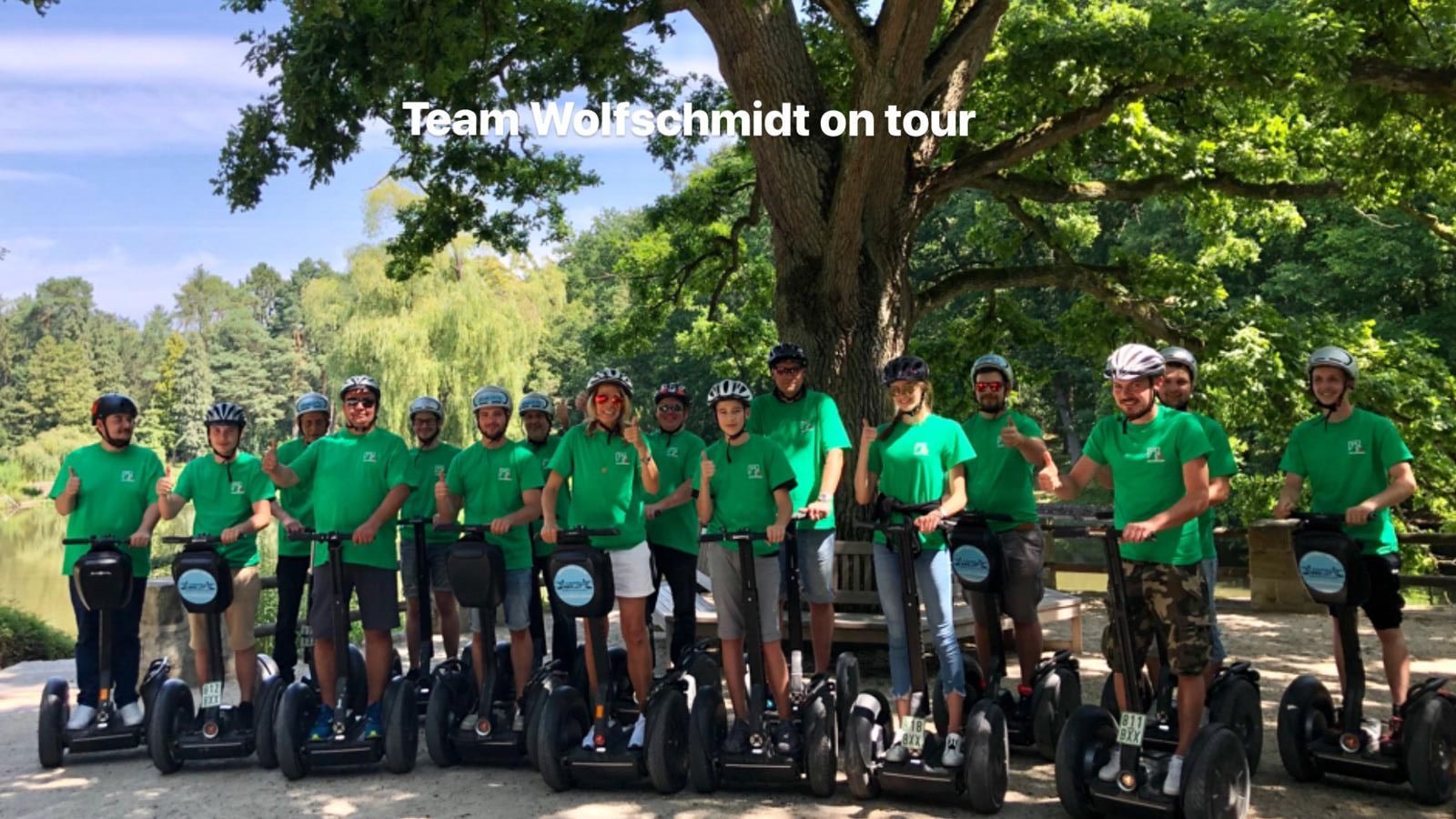 Eine Gruppe von Menschen steht nebeneinander auf Segways.