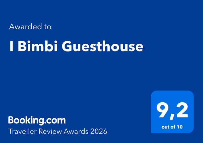 A blue Booking.com award graphic for I Bimbi Guesthouse, displaying a 9.2 rating and the text 