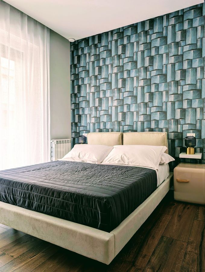 A hotel room with two beds , a lamp and a mirror.