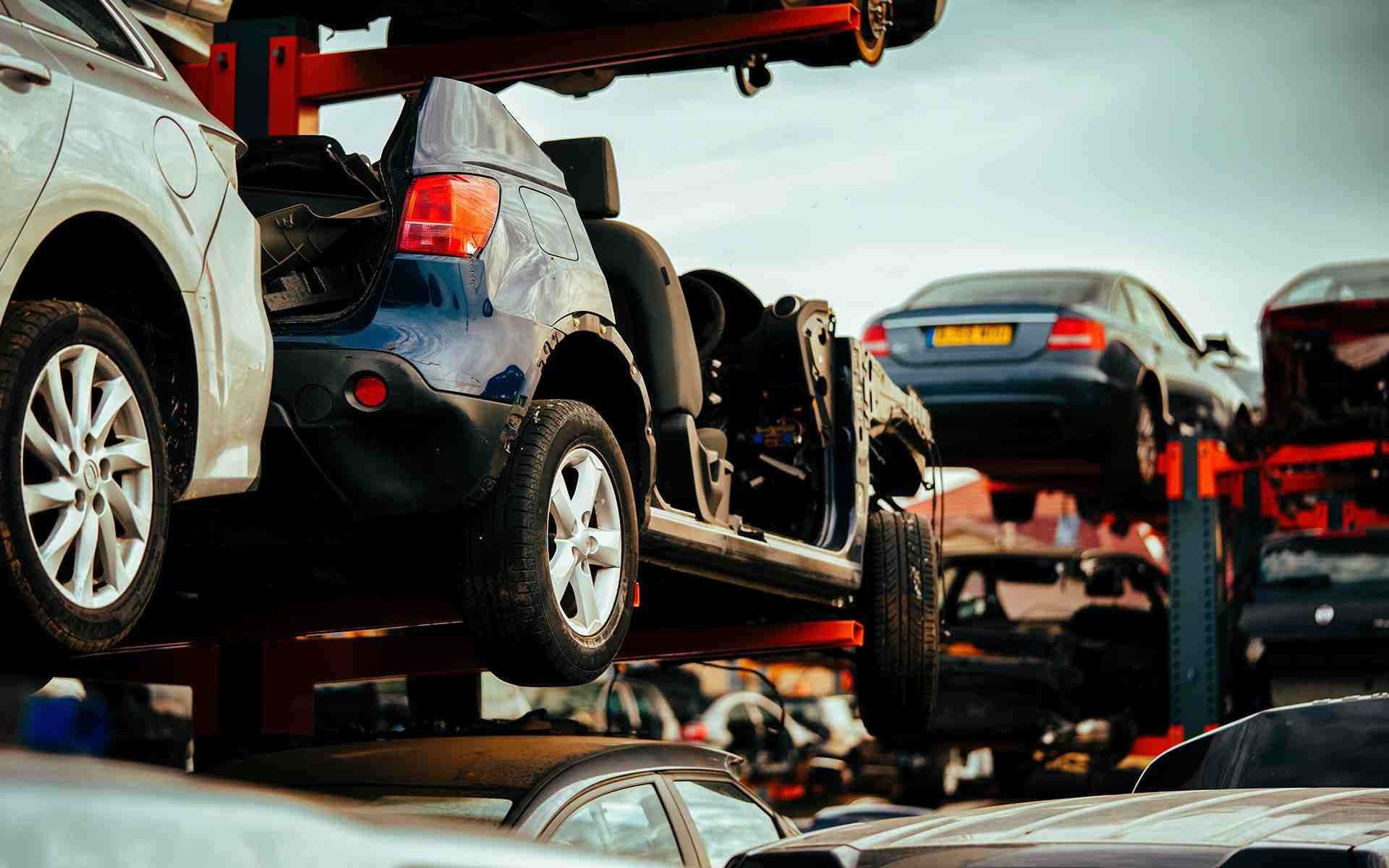 Un montón de coches están apilados uno encima del otro en un depósito de chatarra.