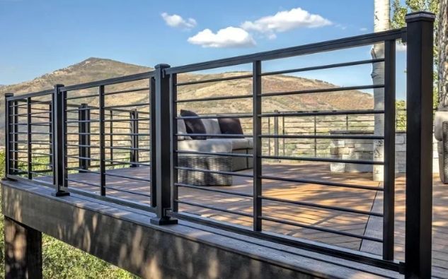 Un primer plano de una valla de hierro forjado negra con un fondo borroso.