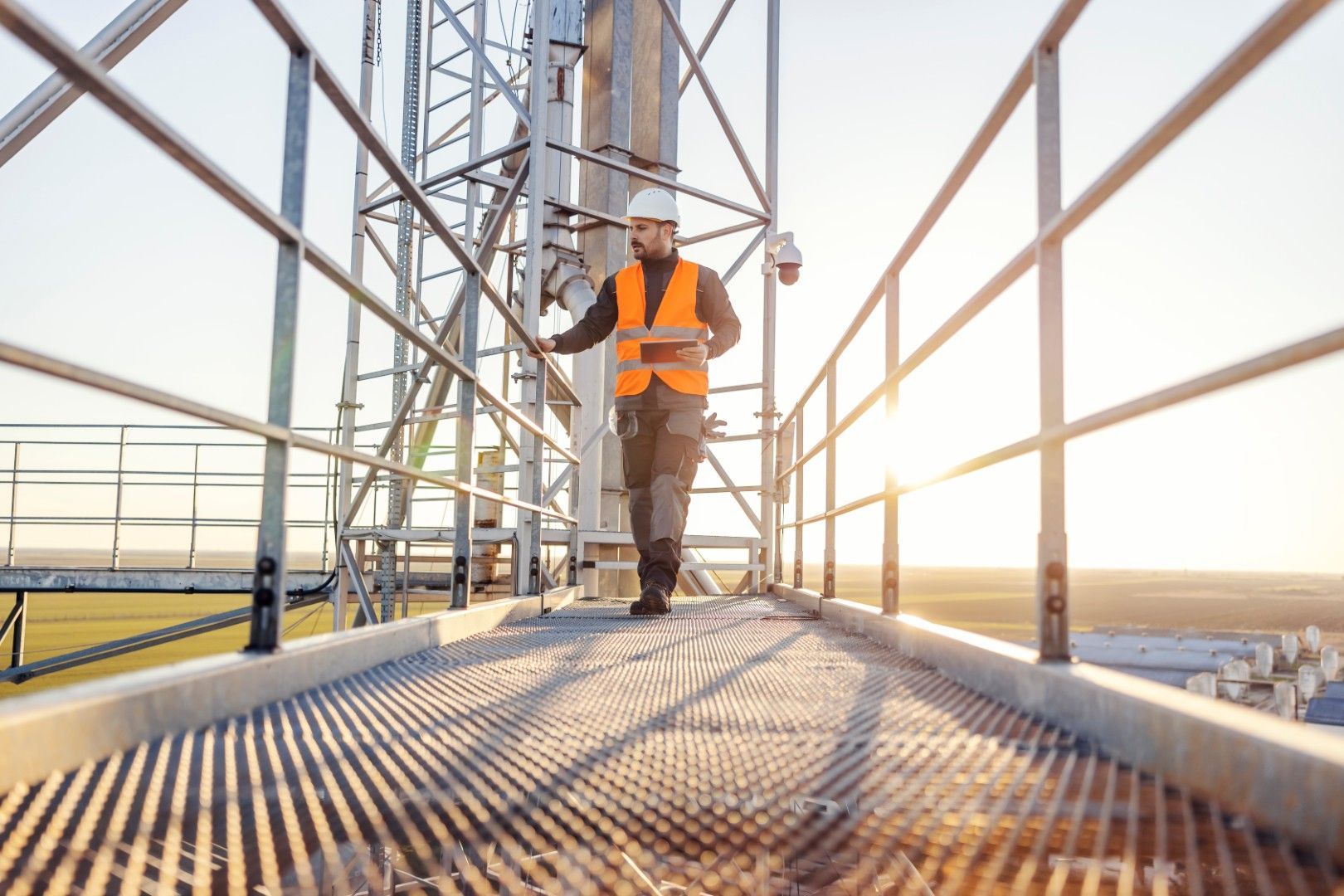 Frau mit Schutzbrille und Handschuhen arbeitet mit Maschinen in einer Fabrik.