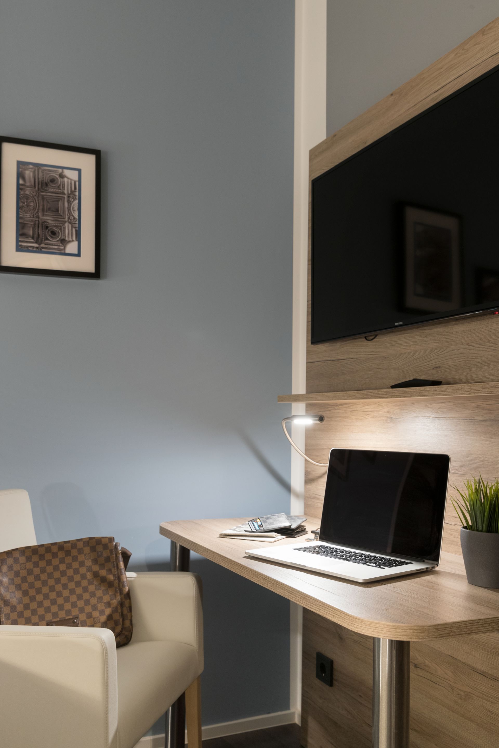 Ein Wohnzimmer mit einem Stuhl und einem Schreibtisch mit einem Laptop darauf