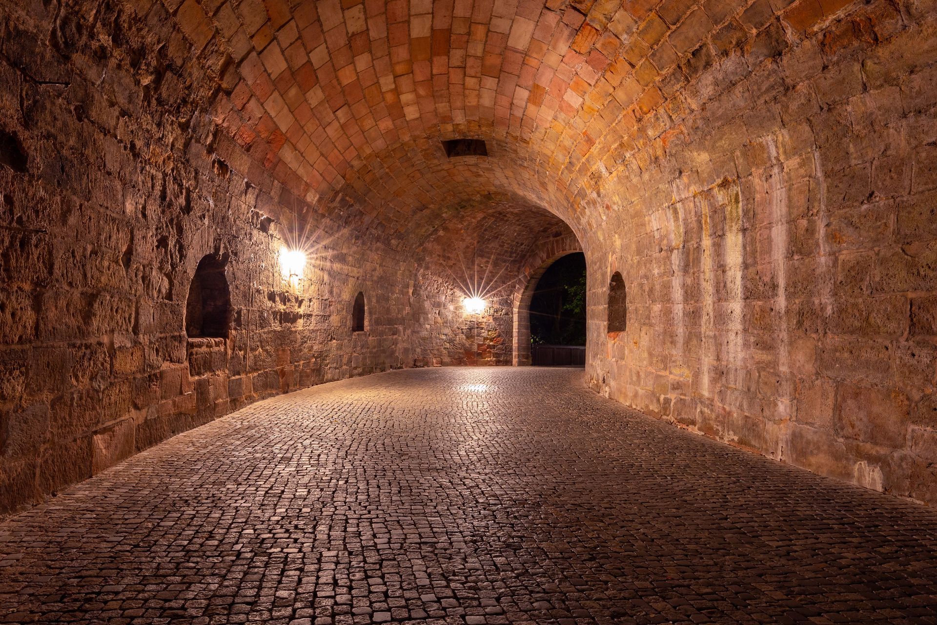 Ein Tunnel mit Ziegelwänden und Kopfsteinpflasterboden