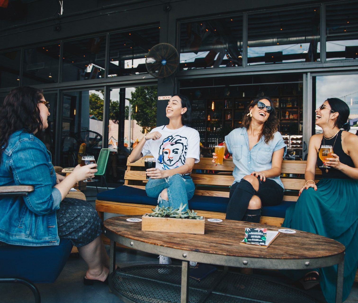 Eine Gruppe von Frauen sitzt lachend um einen Tisch