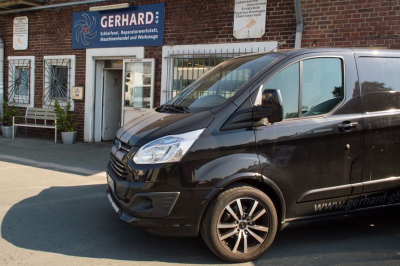 Ein schwarzer Lieferwagen steht vor einem Backsteingebäude.