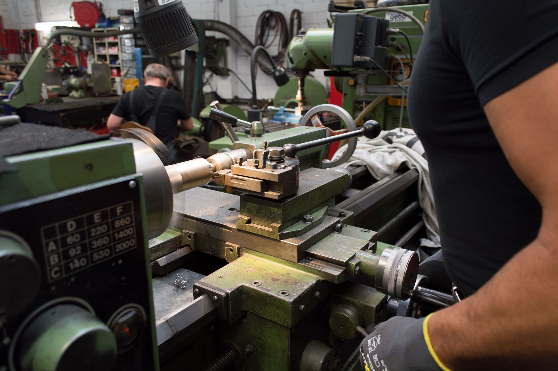 Ein Mann arbeitet in einer Fabrik an einer Drehbank.