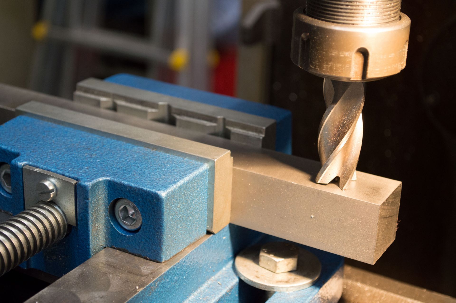 Mit einem Bohrer wird ein Loch in ein Metallstück gebohrt.