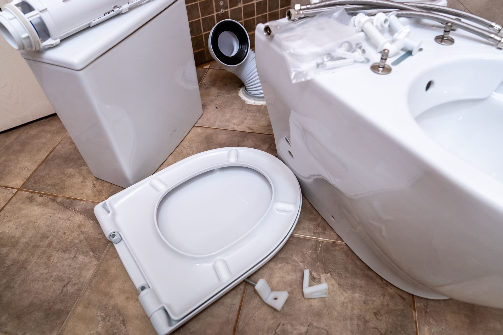 Toilettes et éléments plomberie disposés sur le sol.