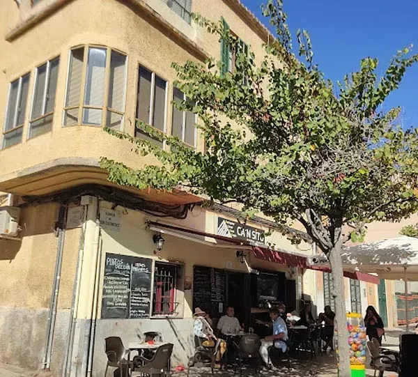 Un grupo de personas están sentadas afuera de un restaurante llamado el coast