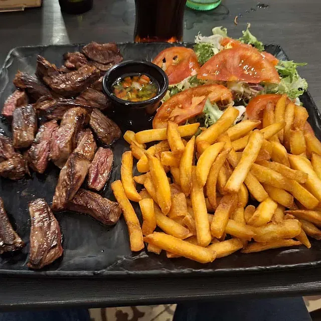 Un plato de bistec y papas fritas en una mesa