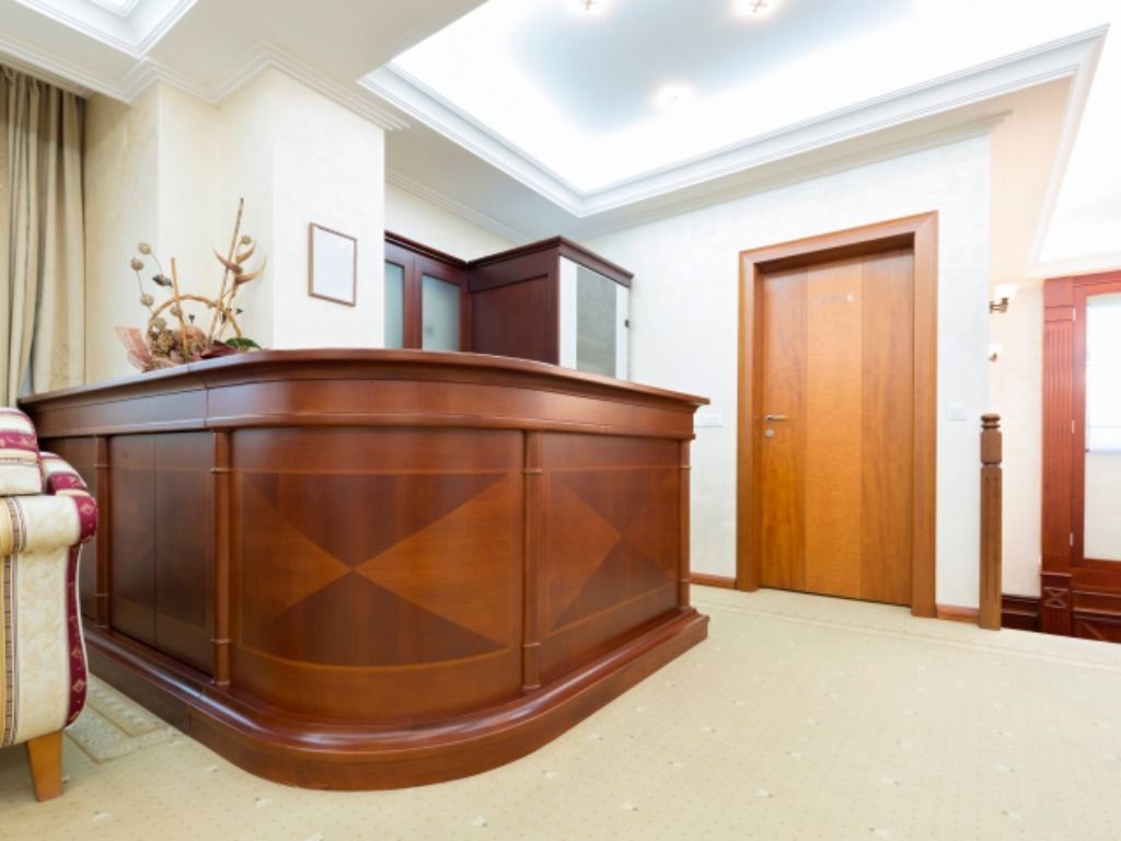 Un mostrador de recepción de madera en el vestíbulo de un hotel.
