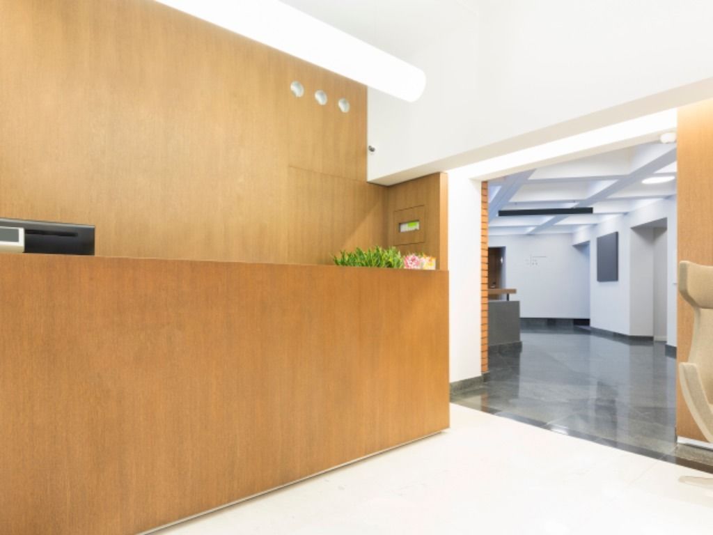 Un área de recepción con un mostrador de madera y una silla.
