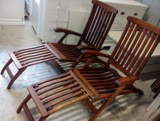 Dos sillas de madera con otomanas en el suelo.