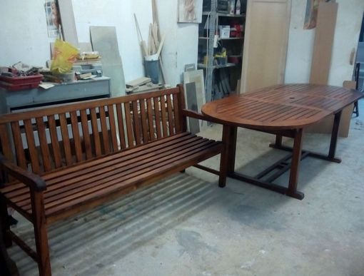 Un banco de madera se encuentra junto a una mesa de madera.