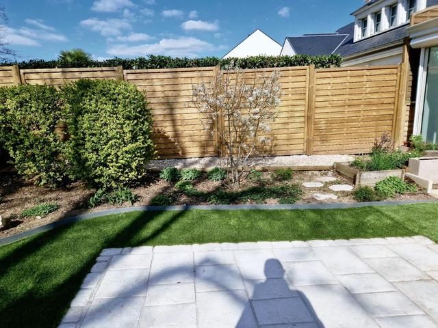 Entretien d'un jardin avec arbustes et diverses plantations.