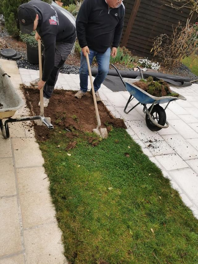 Les paysagistes préparent le sol avec des pelles.