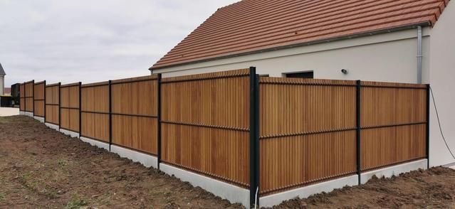 Le terrain d'une maison entouré d'une clôture en bois.