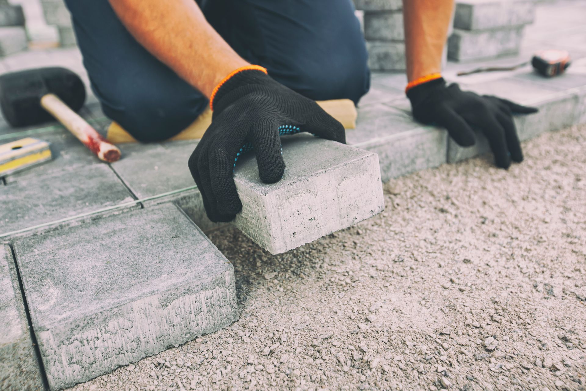 Le professionnel pose des dalles pour créer une allée.