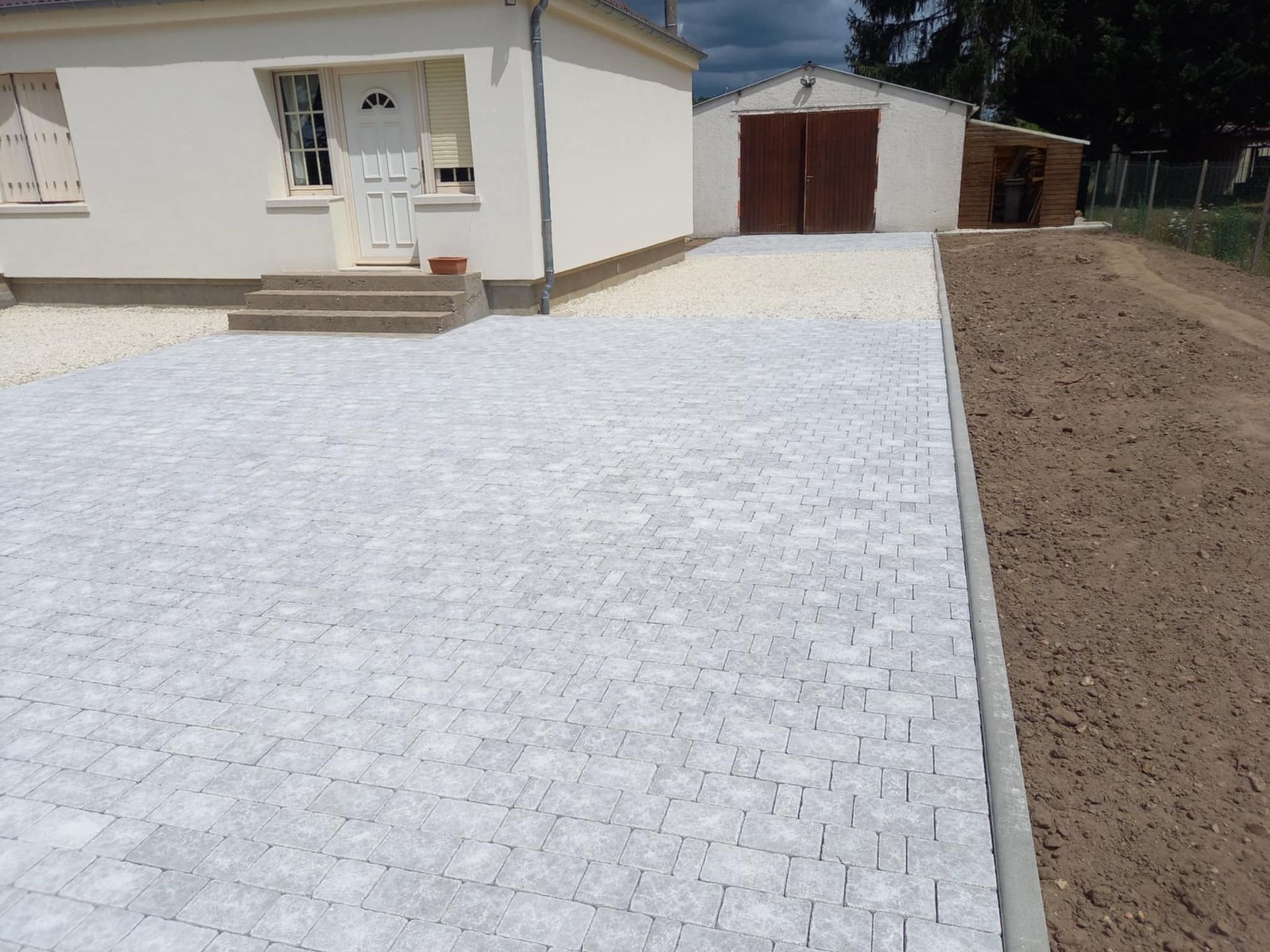 Cour et allée de maison en pavage avec bordure.